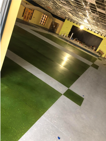 A green and white patterned polished concrete floor in a showroom.